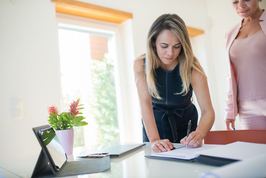 A business owner signing UAE company incorporation documents in a bright Dubai office