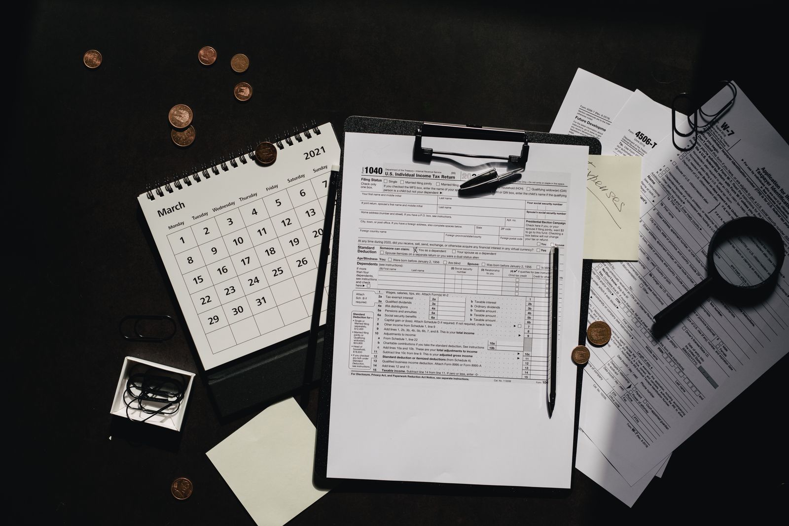 UAE Corporate Tax documents, calendar and magnifying glass on an office desk