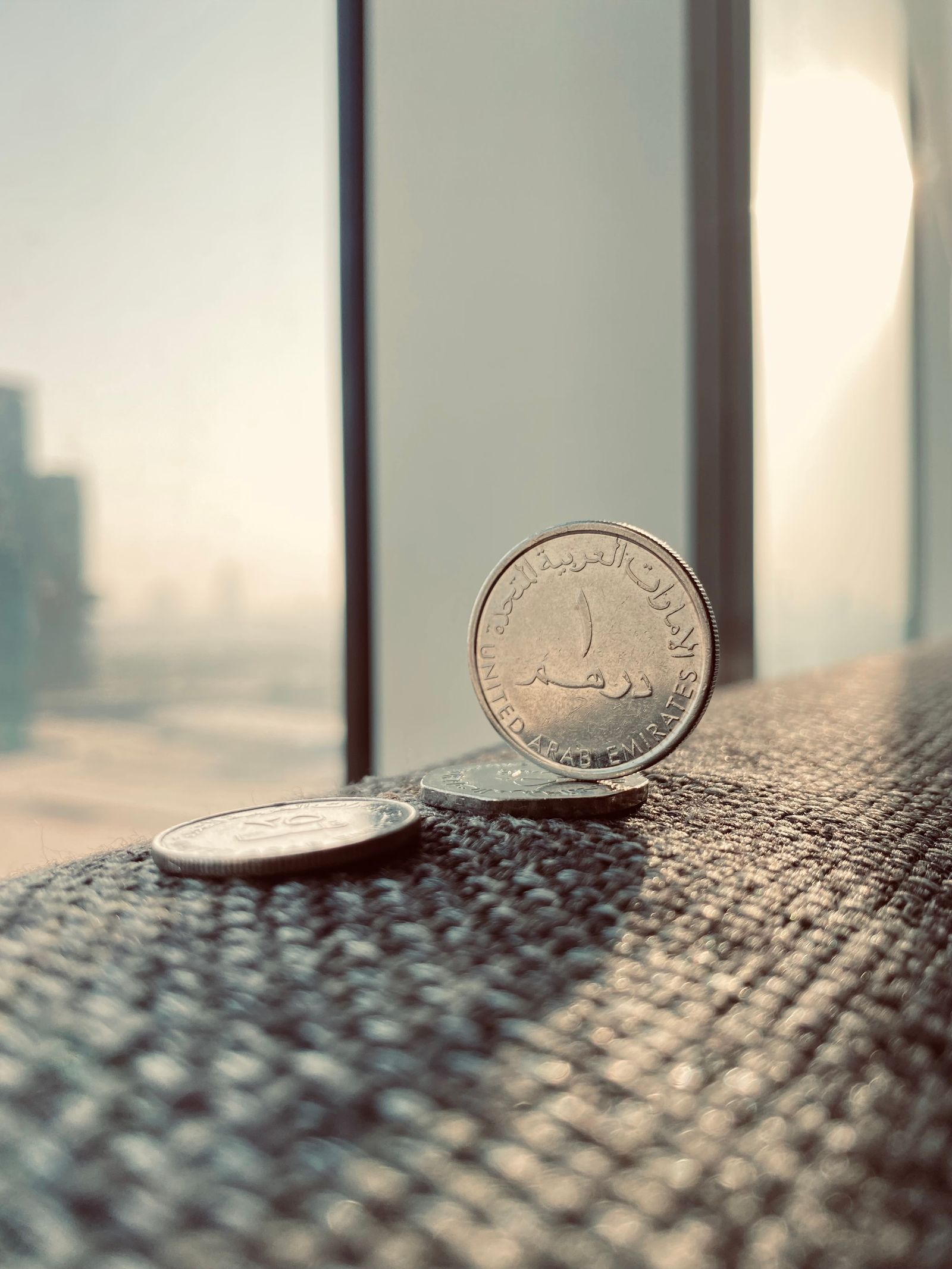 UAE dirham coins with the Dubai skyline in the background